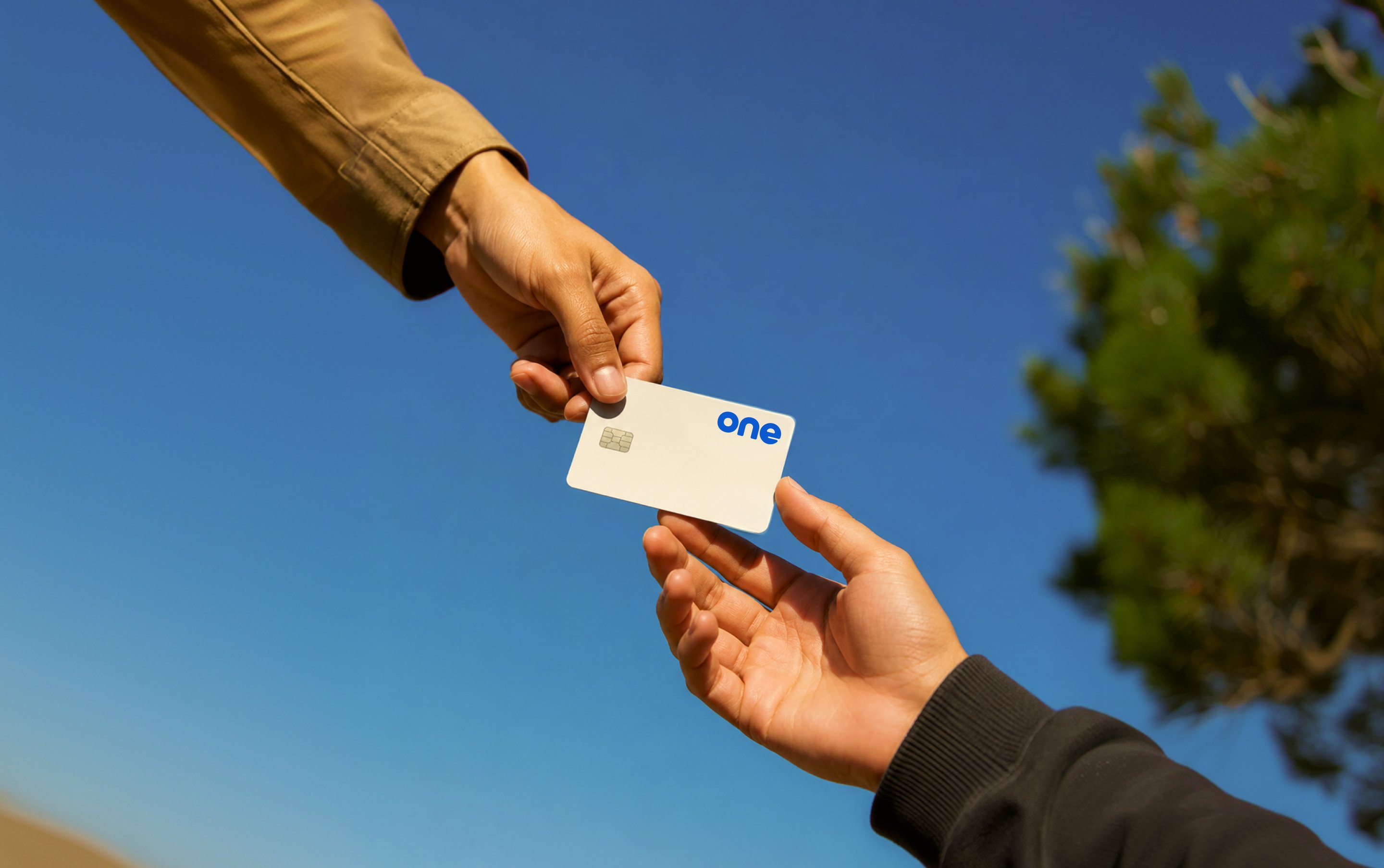 Two people exchanging a One card